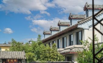 There is a row of houses on one side and two rows of houses in front, with one of them being renovated at Fuzi Binshe Family Education Culture Boutique Hotel