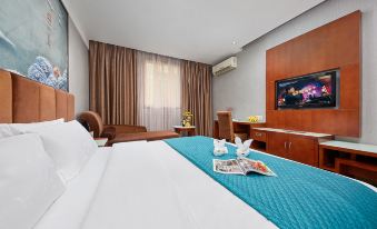 The main bedroom area features a double bed and a large flat-screen television at Kaiserdom Hotel (Guangzhou Baiyun Airport)