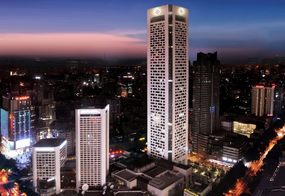 The city skyline is illuminated at night, with skyscrapers in the foreground at Jinling Hotel