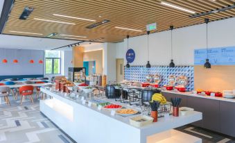 The restaurant features an open concept design with tables, chairs, and a counter at Holiday Inn Express Shanghai Pudong Airport