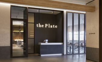 a modern office space with a black and white checkered floor , a white reception desk , and a glass door at Lahan Hotel Jeonju