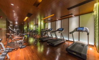 A spacious room is equipped with multiple treadmills and other gym equipment along one of the walls at Boyue Hotel Shanghai Air China Hongqiao Airport