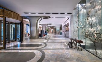 The lobby features a modern design with a spacious floor-to-ceiling window connecting to another area at Elegant Hotel Shanghai Bund