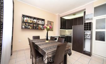 a dining room with a wooden table , chairs , and a wine rack filled with bottles at D&D Apartments