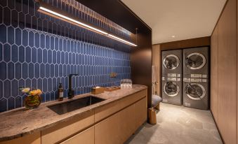 There is a modern kitchen in the laundry room, which includes an automatic washing machine and a sink at Crystal Orange Beijing Shangdi Zhongguancun Software Park Hotel