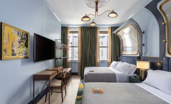 a modern hotel room with two beds , a desk , and a window , decorated in blue and white colors at Canopy by Hilton Philadelphia Center City