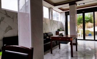 A room with marble floors and walls is connected to an open dining area along the hallway at Shengsi wolfberry island on the island to the fisherman's family