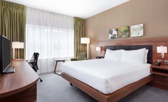 a large bed with white sheets is in a hotel room next to a window at Hilton Garden Inn Sunderland