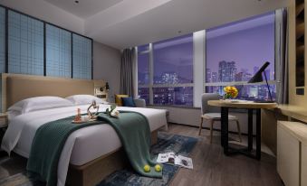 The bedroom features large windows and a bed in the center, with an open space beside it at Echarm Hotel (Guangzhou Beijing Road Pedestrian Street Tianzi Pier)