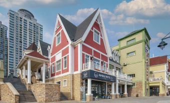 a brick building with a red and white exterior , situated in a town square surrounded by tall buildings at Amble Hotel