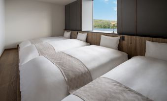 There is an empty room with two beds and a large window in the middle on one side at Hoshino Resorts KAI Poroto