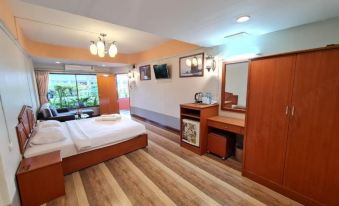 a modern hotel room with wooden flooring , large windows , and a comfortable bed , as well as a desk and a tv at Phu nga Hotel