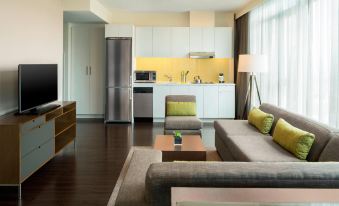 a modern living room with a couch , chairs , and a dining table in the background at Element Vancouver Metrotown