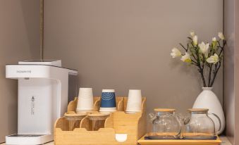 A wooden tray with cups and mugs is placed in the middle of the room at Pebble Hotel (Shanghai New International Expo Center Longyang Road Metro Station)