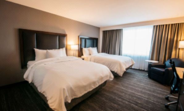 a hotel room with two beds , one on the left and one on the right side of the room at The Explorer Hotel