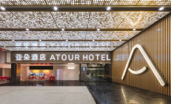 The entrance to a building is marked by an illuminated sign on its ceiling and additional signage in front at Guangzhou Atour Hotel(Zhujiang New Town Wuyangcun Subway Station)