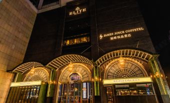 At night, a hotel entrance is adorned with an illuminated sign above its glass door at Guangzhou Tianhe Taikoohui - Coffee Rupin Hotel