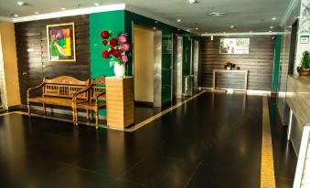 The lobby features wood paneling, tiled floors, and artwork displayed along the wall at Hotel Capital Kota Kinabalu