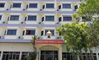 a large white building with multiple windows and balconies , possibly a hotel or office building at The Great Rayong Hotel