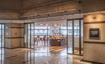a modern office building with large glass doors and a view of the outside through the open doorway at HOTEL MYSTAYS Utsunomiya