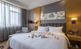 a well - decorated hotel room with a king - sized bed , white linens , and a painting on the wall at Orient Hotel