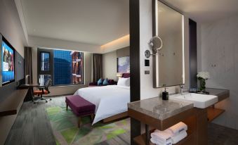 A modern bedroom with large windows, a bed, and a desk in the middle is located next to at Hampton by Hilton Beijing Guomao CBD