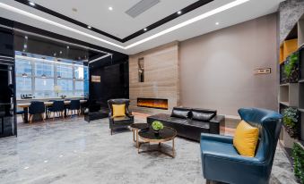 The living room is open and features large windows, as well as chairs and couches in the center at Homeinn Selected Hotel (Shanghai The Bund City God Temple)