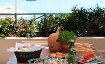 a dining table set with a variety of food items , including fruits , sandwiches , and drinks at The Diplomat Hotel