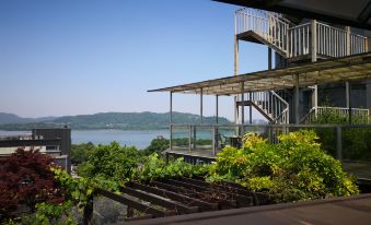 The balcony offers a scenic view of the ocean, with houses on both sides at Merchant Marco Edgelake Hotel