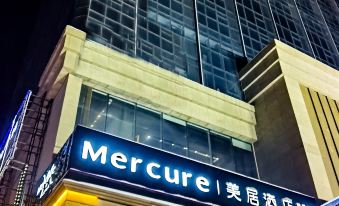 "a large building with a sign that reads "" mercure "" prominently displayed on the front of the building" at Mercure Urumqi South Lake