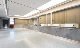 There is a spacious room with an unoccupied counter in the center at Ji Hotel (Guangzhou Tianhe Sports Center)