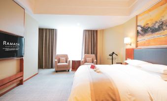 Another bedroom with a large bed and a chair next to the window is available at Ramada Plaza by Wyndham Shanghai Pudong Airport