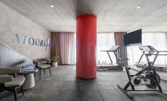 A spacious room with an indoor gym area and decorative wall lights at Guangzhou Atour Hotel(Zhujiang New Town Wuyangcun Subway Station)