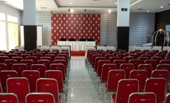 a conference room with rows of red chairs arranged in front of a stage , ready for a meeting or event at Hotel Bonero Residence