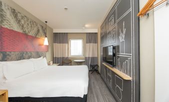 A standard room in the hotel's main living area includes a double bed and a large flat-screen television at Ibis Hotel (Shanghai New International Expo Center FangDian Road Subway Station)