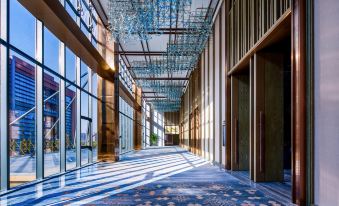 A long, empty building with a hallway featuring ceiling windows and tiled floors at LEFUQIANG BOYUE HOTEL