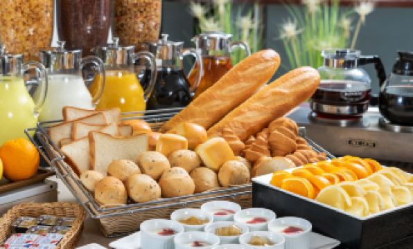 a dining table with a variety of food items , including bread , pastries , and other snacks at HOTEL MYSTAYS Utsunomiya