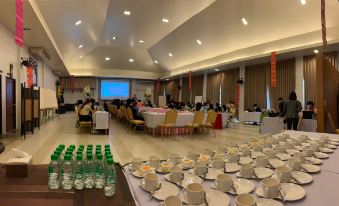 a conference room with a large table , chairs , and water bottles set up for an event at Poonyamantra Resort