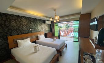 a hotel room with two beds , one on the left and one on the right side of the room at Rapeepong Resort Nanthai