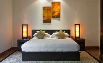a large bed with a black headboard and white linens is shown in a bedroom at The Fortress Resort & Spa