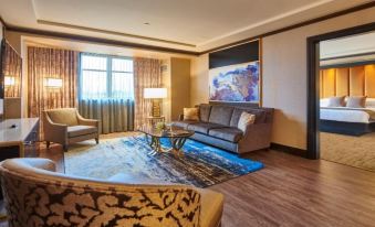 a modern living room with wooden flooring , large windows , and comfortable seating arrangements , including a blue rug with gold accents at Mount Airy Casino Resort - Adults Only 21 Plus