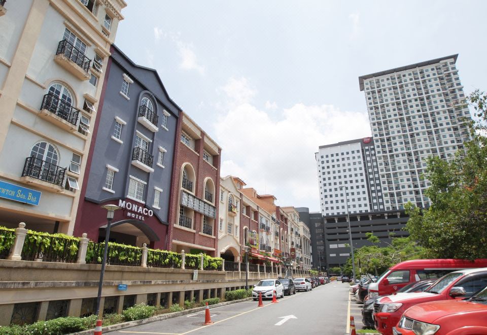 a city street with buildings on both sides and cars parked on the side of the road at Monaco Hotel Cyberjaya