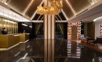 The lobby is illuminated by a large chandelier hanging from the ceiling, casting reflections at Atour S Hotel Zhongbei Road  Chuhe Han Street