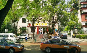 cars are parked on the side of the street and pedestrians are walking near an intersection at Super 8 Hotel Premier (Beijing Workers' Stadium Sanlitun Chunxiu Road)