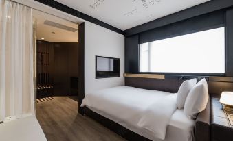 A modern bedroom features large windows, a white bed in the center, and an open layout at CitiGO Hotel Jing'an Shanghai