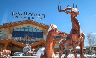 "a large building with a sign that says "" pullman resorts "" is next to two deer statues" at Pullman Changbaishan Resort
