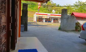 a view of a building with a red and white sign in the background , possibly a gas station at 77 Sunset Plaza