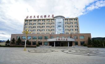 a large hotel building with a courtyard in front of it , surrounded by a brick wall at Frontier Building