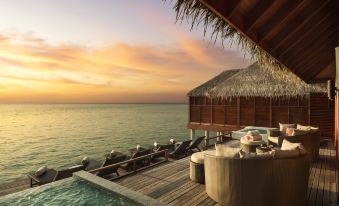 a wooden deck overlooking the ocean , with a hot tub and lounge chairs situated on the deck at Anantara Dhigu Maldives Resort