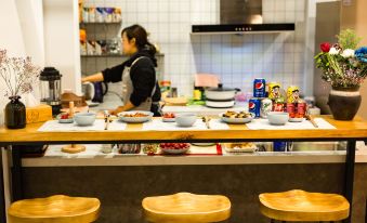 a woman in a black shirt is standing at a counter with various bowls and drinks on it at yhz